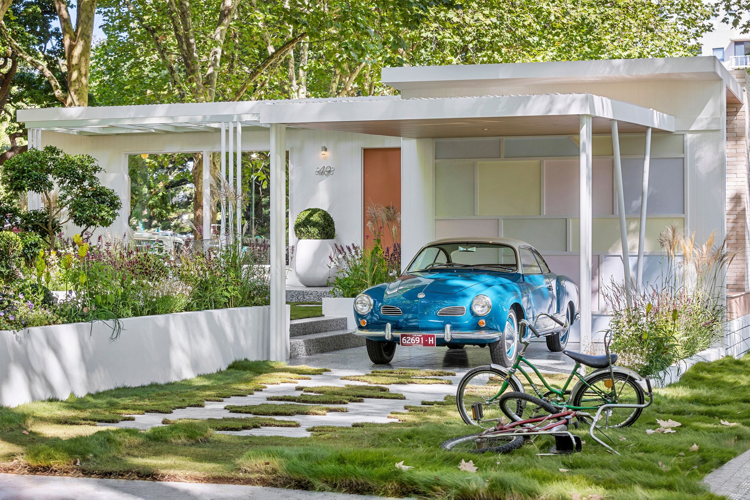 Pergola over lawn with stepper path and period bicycle